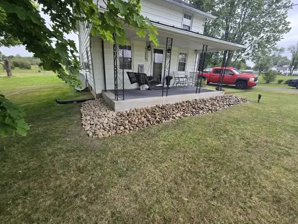 Front porch with a new river rock border and trimmed lawn