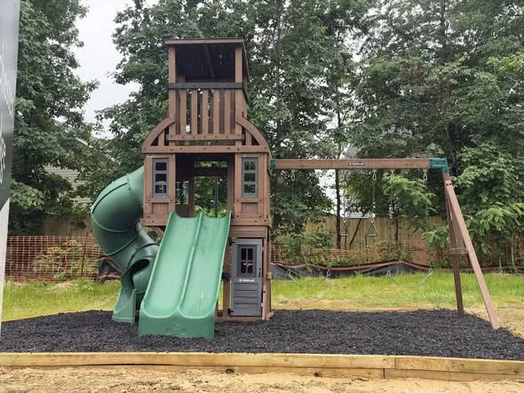 Completed playset with timber-edged mulch surround