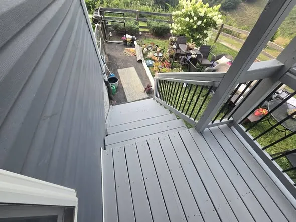 Deck stairs and landing leading down to a stone patio